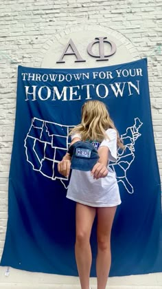 a woman standing in front of a sign that reads throwdown for your home town