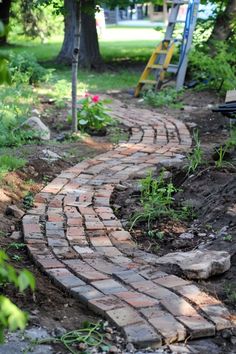 a brick path in the middle of a garden