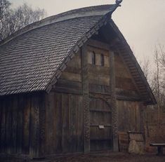 an old wooden building with a roof made out of wood planks and shingles