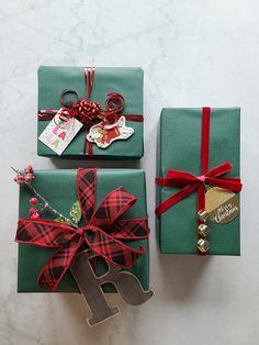 two presents wrapped in green paper and tied with red ribbon are sitting next to each other