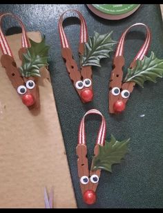 three christmas decorations made to look like carrots with eyes and holly leaves on them