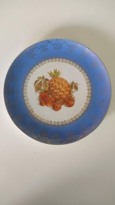 a blue and white plate with some fruit on the rim, sitting on a table