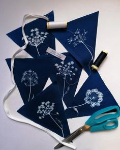 scissors, thread and fabric with dandelion designs on them sitting next to each other