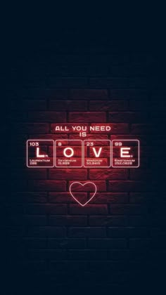 a neon sign that says all you need is love on the side of a brick wall