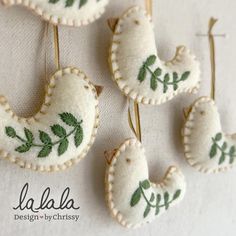 four embroidered brooches with green leaves on them