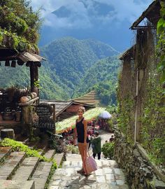 a woman is walking up some steps in the mountains