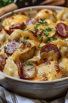 a casserole dish with ham, cheese and sausage in it on a table