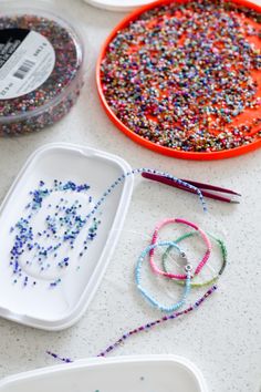 the table is covered with crafting supplies such as beads, scissors and sprinkles