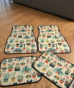 four pot holders with plants on them sitting on the floor