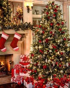 a decorated christmas tree in front of a fire place with stockings on the mantles