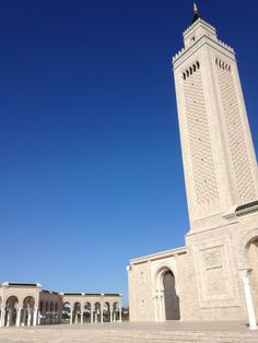 a tall white tower with a clock on it's side