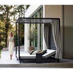 a woman is walking past an outdoor bed