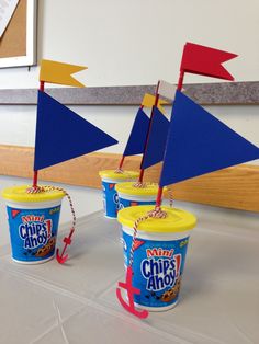 three ice cream cups with small sailboats on top and one cup filled with chips ahoy