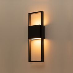 a wall mounted light on the side of a white wall