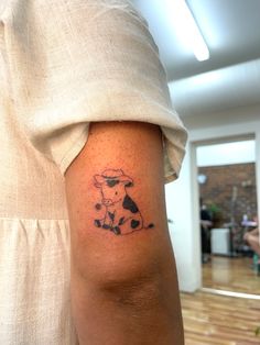 a person with a cow tattoo on their arm