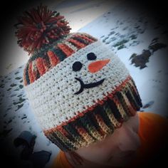 a child wearing a crocheted snowman hat