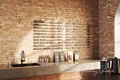 a kitchen counter with wine glasses on it and a brick wall in the back ground