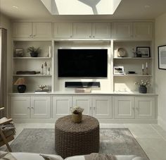 a living room filled with lots of furniture and a flat screen tv mounted on the wall