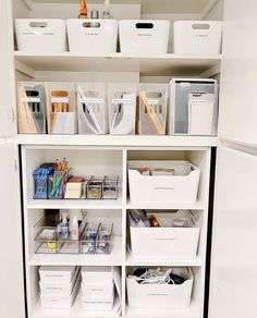 an organized pantry with white bins and plastic containers