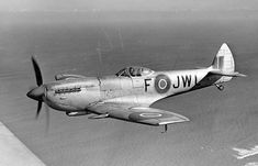 an old airplane flying in the sky over water