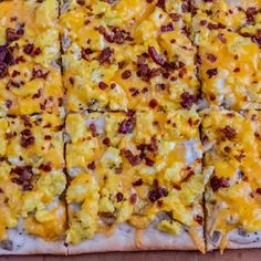 a square pizza with cheese and bacon on it