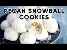 a black plate topped with snowball cookies on top of a blue tablecloth and text overlay reads pecan snowball cookies