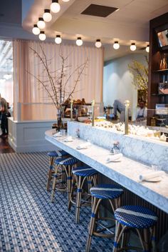 an empty restaurant with blue stools and white counter tops