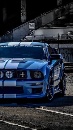 a blue and white mustang car parked on the street