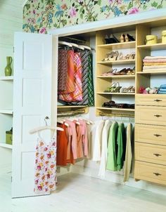 an open closet with clothes hanging on it