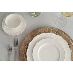 a table setting with plates, silverware and wine glasses