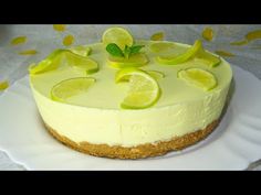 a cheesecake topped with lime slices on top of a white plate