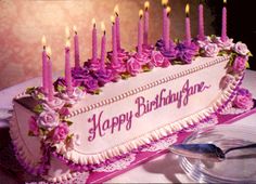 a birthday cake with pink flowers and candles