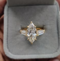 a person holding an engagement ring in their hand with the diamond on it's side