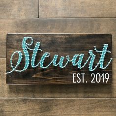 a wooden sign that says stewart est 2019 on the side of a wood plank wall