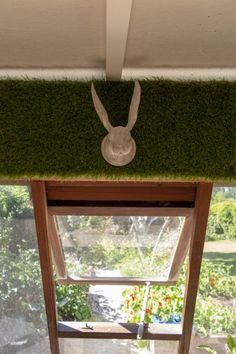 a window sill with moss growing on the top and an animal head in the middle