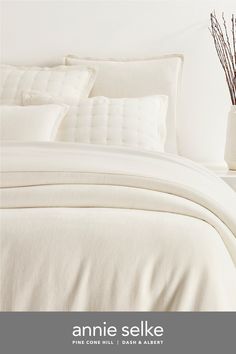 an image of a bed with white sheets and pillows in the room that says annie selke