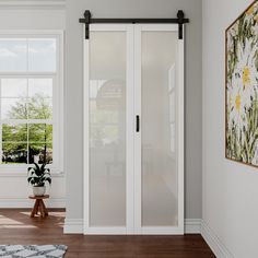 an empty room with white walls and wooden flooring is shown in front of a large window