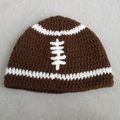 a crocheted beanie with a football on the side and white stitching