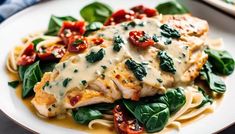 a white plate topped with chicken and spinach covered in sauce on top of pasta