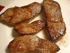 some meat is on a white plate and ready to be cooked in the oven for consumption