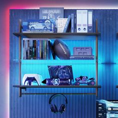 a computer desk with headphones, books and other items on it in front of a blue wall