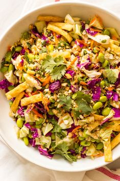 a white bowl filled with lots of food on top of a table