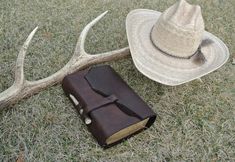 a book, hat and deer antlers on the ground