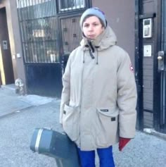 a man standing in front of a building holding a suitcase