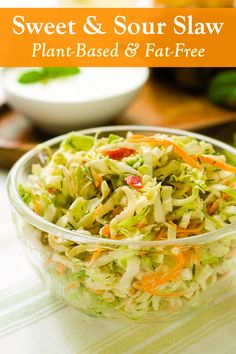 a glass bowl filled with coleslaw and carrots on top of a table