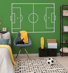 a bedroom with a soccer field painted on the wall next to a bed and chair