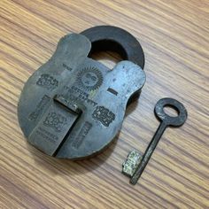 an old lock and key on a wooden table