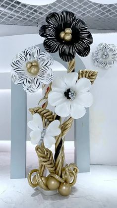 a vase with flowers on it sitting in the middle of a room filled with white and black decorations