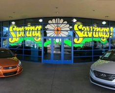 two cars are parked in front of a store