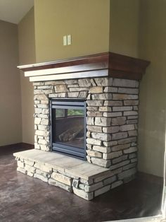 an empty room with a stone fireplace in it